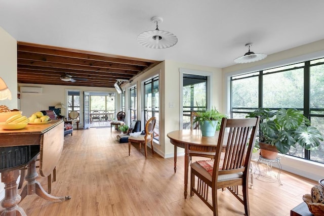 sunroom / solarium featuring a wall mounted air conditioner, wood finished floors, and plenty of natural light