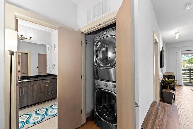 3600 S Lamar Blvd Unit 211, Austin, TX 78704 - laundry room featuring stacked washer / dryer and light wood finished floors
