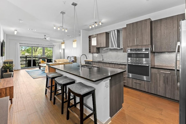 3600 S Lamar Blvd Unit 211, Austin, TX 78704 - kitchen with stainless steel appliances, wall chimney range hood, open floor plan, dark countertops, and modern cabinets