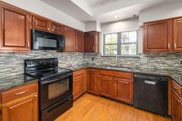 1704 W Ave Unit 108, Austin, TX 78701 - kitchen featuring black appliances, a sink, light wood finished floors, dark stone counters, and tasteful backsplash