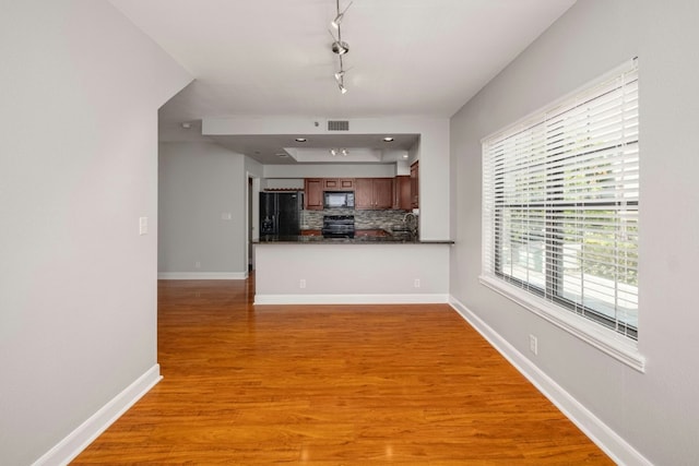 1704 W Ave Unit 108, Austin, TX 78701 - unfurnished living room with track lighting, light wood finished floors, and baseboards