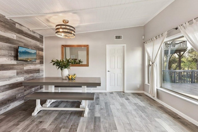 7067 Comanche Trl, Austin, TX 78732 - dining space featuring wood walls, wood finished floors, wood ceiling with exposed beams, a chandelier, and baseboards