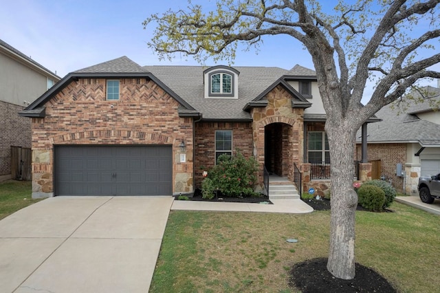 2429 Carretera Dr, Leander, TX 78641 - view of front facade featuring a shingled roof, brick siding, concrete driveway, a front lawn, and stone siding