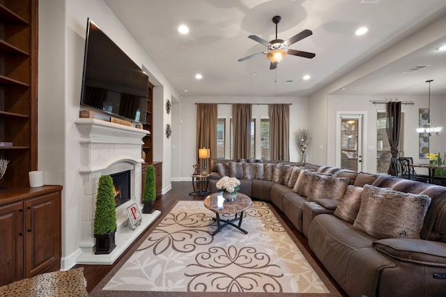2429 Carretera Dr, Leander, TX 78641 - living room with a ceiling fan, dark wood-type flooring, recessed lighting, a lit fireplace, and baseboards