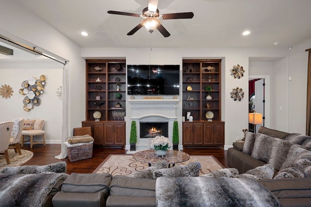 2429 Carretera Dr, Leander, TX 78641 - living room with a ceiling fan, a warm lit fireplace, dark wood finished floors, baseboards, and recessed lighting