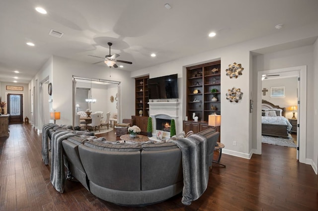 2429 Carretera Dr, Leander, TX 78641 - living room featuring ceiling fan, baseboards, a warm lit fireplace, dark wood-style floors, and recessed lighting