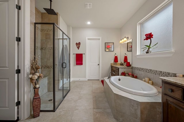 2429 Carretera Dr, Leander, TX 78641 - full bath featuring vanity, a shower stall, a garden tub, tile patterned floors, and recessed lighting
