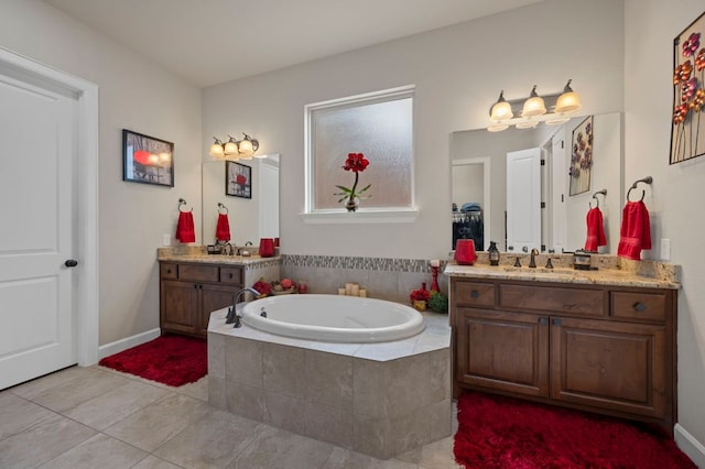 2429 Carretera Dr, Leander, TX 78641 - bathroom with tile patterned flooring, a garden tub, two vanities, and baseboards