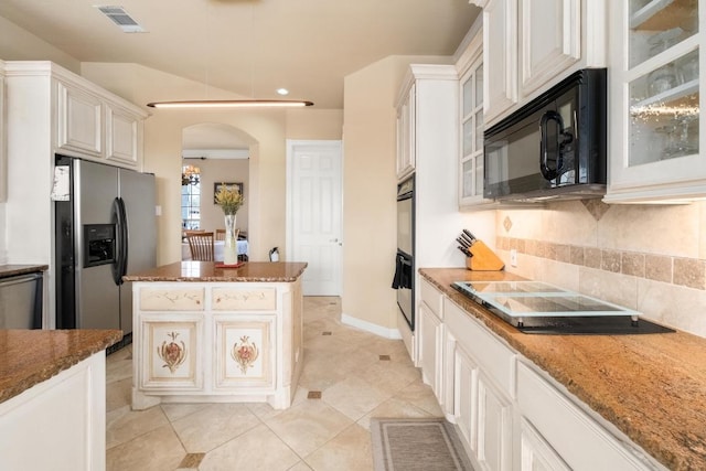 329 Park Place Dr, Georgetown, TX 78628 - kitchen with black appliances, arched walkways, tasteful backsplash, light tile patterned floors, and dark stone counters