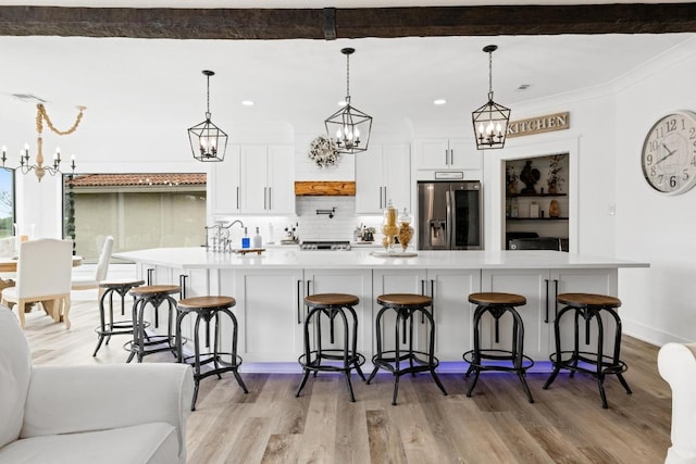 kitchen with an inviting chandelier, light countertops, and stainless steel fridge