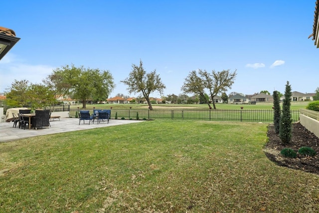 view of yard with a patio area, a fenced backyard, and a residential view