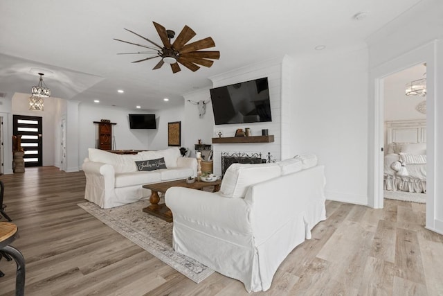 30224 Briarcrest Dr, Georgetown, TX 78628 - living area with a fireplace, baseboards, ceiling fan with notable chandelier, light wood-style floors, and recessed lighting