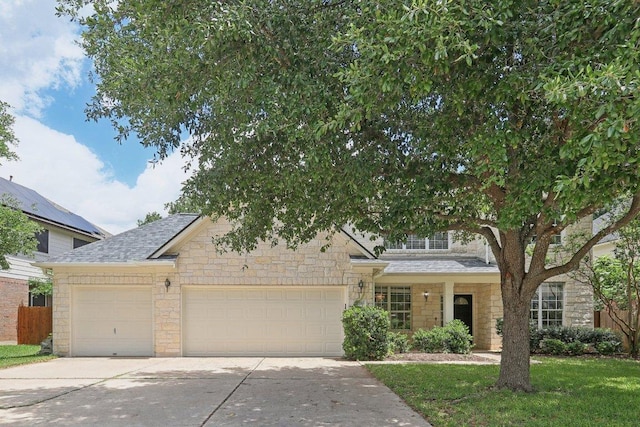 obstructed view of property featuring stone siding, an attached garage, concrete driveway, and roof with shingles