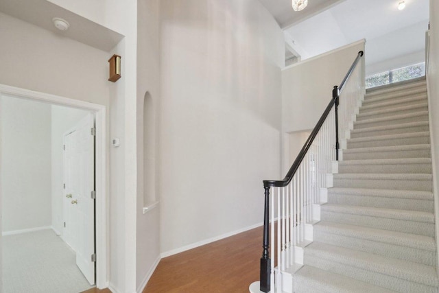 stairway with baseboards and wood finished floors
