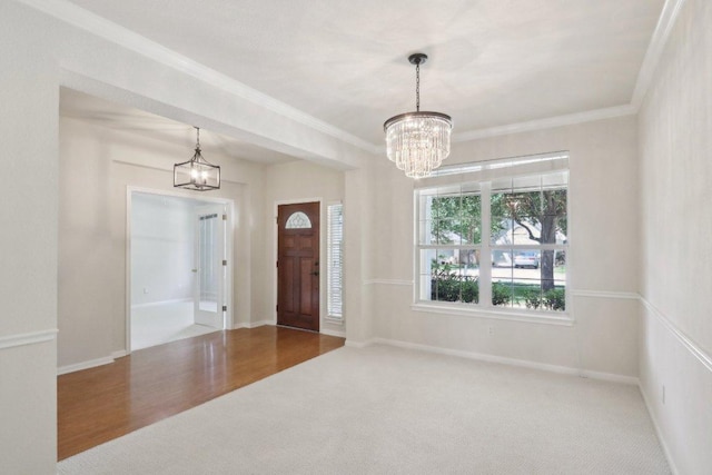 entryway with a chandelier, ornamental molding, baseboards, and carpet floors