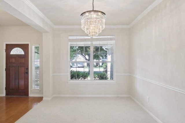 foyer featuring a chandelier, plenty of natural light, crown molding, carpet, and baseboards