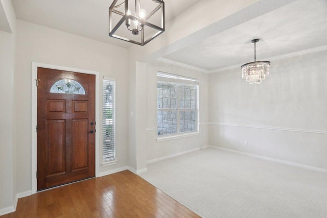 entryway with a chandelier, plenty of natural light, hardwood / wood-style flooring, and baseboards