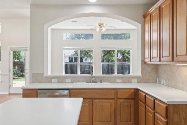kitchen with a sink, dishwasher, a ceiling fan, and arched walkways