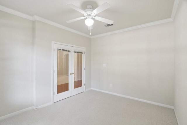 spare room featuring french doors, ornamental molding, light carpet, baseboards, and a ceiling fan