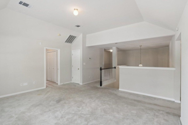 empty room featuring lofted ceiling, baseboards, and carpet flooring