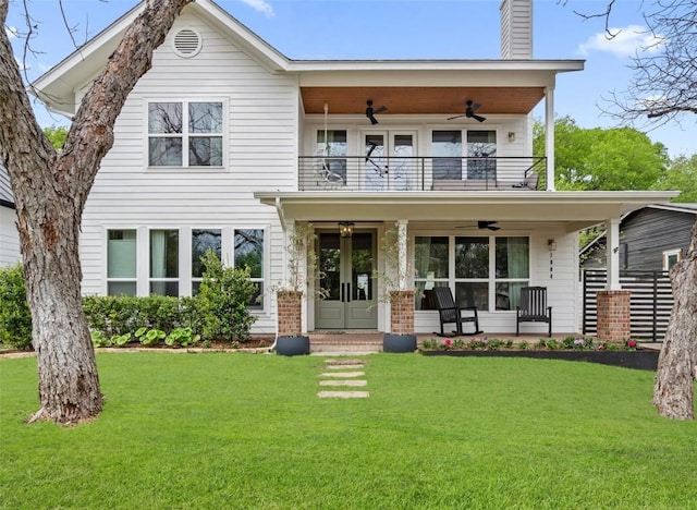 view of front of property featuring a porch, a balcony, a front yard, and ceiling fan
