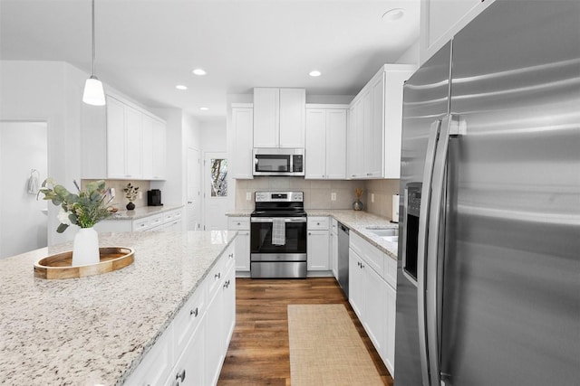 kitchen with backsplash, white cabinets, stainless steel appliances, and dark wood-style floors