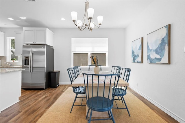 dining space with baseboards, light wood-style flooring, recessed lighting, and a chandelier