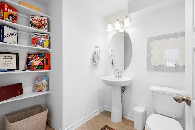 bathroom with baseboards, toilet, and tile patterned flooring