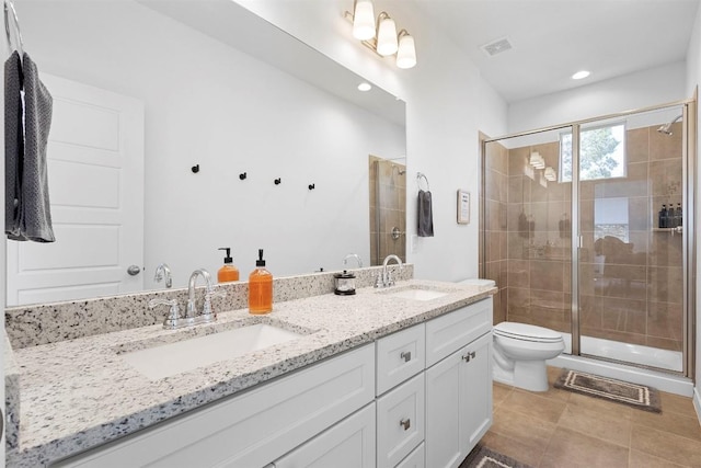 bathroom with toilet, a sink, double vanity, and a shower stall