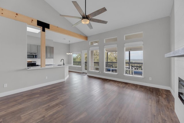 20912 High Dr, Lago Vista, TX 78645 - unfurnished living room featuring a sink, a glass covered fireplace, dark wood-style flooring, a chandelier, and high vaulted ceiling