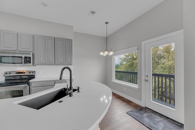 20912 High Dr, Lago Vista, TX 78645 - kitchen featuring stainless steel appliances, wood finished floors, hanging light fixtures, a chandelier, and light countertops