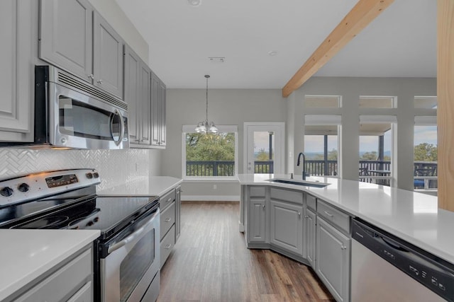 20912 High Dr, Lago Vista, TX 78645 - kitchen featuring stainless steel appliances, a sink, gray cabinets, dark wood-style floors, and beam ceiling