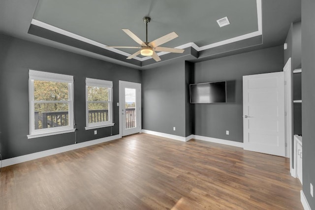 20912 High Dr, Lago Vista, TX 78645 - unfurnished bedroom with a tray ceiling, wood finished floors, access to exterior, baseboards, and ornamental molding