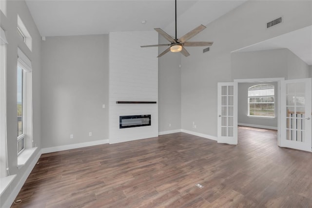 20912 High Dr, Lago Vista, TX 78645 - unfurnished living room featuring high vaulted ceiling, a fireplace, ceiling fan, wood finished floors, and french doors