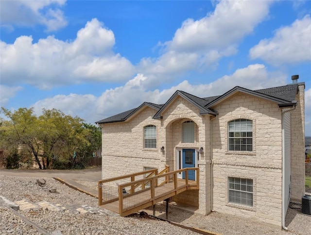 20912 High Dr, Lago Vista, TX 78645 - view of front of home featuring stone siding, roof with shingles, a wooden deck, and central AC