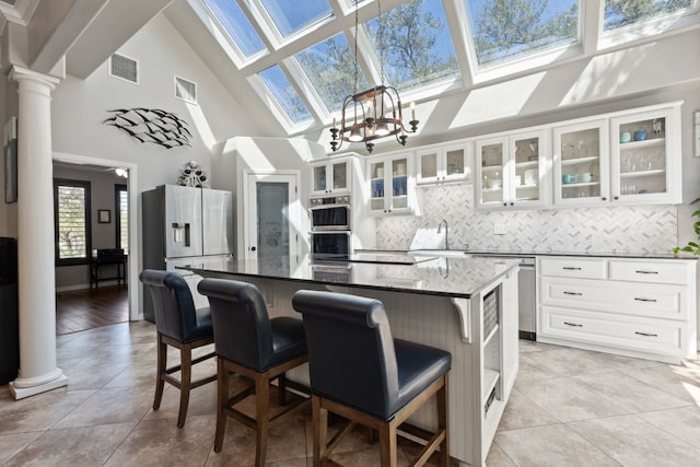 502 Explorer, Lakeway, TX 78734 - kitchen featuring a skylight, high vaulted ceiling, ornate columns, backsplash, and light tile patterned flooring