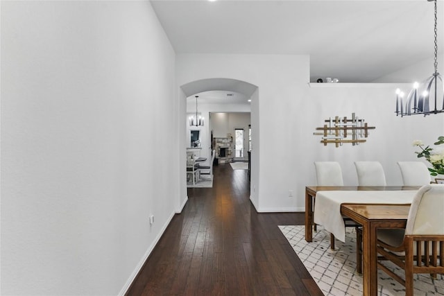 22300 Verbena Pkwy, Spicewood, TX 78669 - dining room featuring a chandelier, arched walkways, and dark wood-style floors
