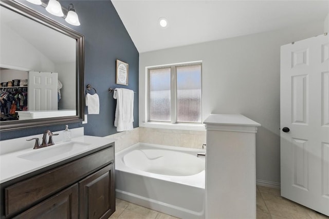 22300 Verbena Pkwy, Spicewood, TX 78669 - full bath with vaulted ceiling, a garden tub, vanity, and tile patterned floors