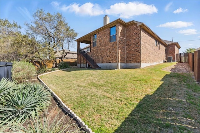 22300 Verbena Pkwy, Spicewood, TX 78669 - back of property featuring brick siding, a chimney, a fenced backyard, and stairway