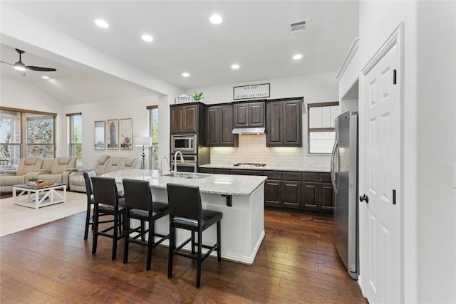 22300 Verbena Pkwy, Spicewood, TX 78669 - kitchen with stainless steel appliances, a ceiling fan, open floor plan, dark brown cabinetry, and recessed lighting