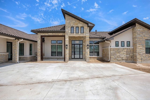 120 NW Strada Luca NW, Florence, TX 76527 - rear view of property with stone siding, stucco siding, and a tile roof