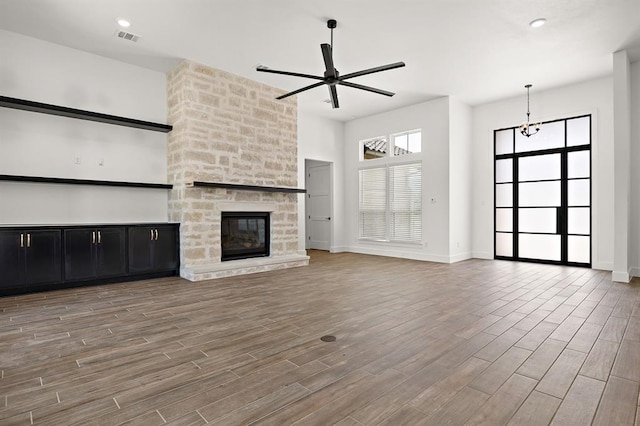 120 NW Strada Luca NW, Florence, TX 76527 - unfurnished living room featuring a ceiling fan, wood finished floors, and a fireplace