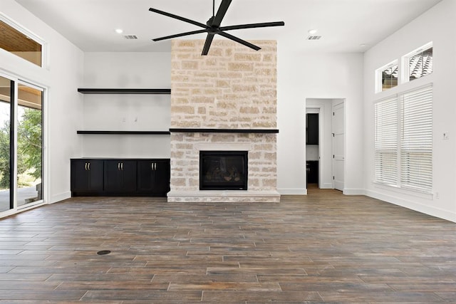 120 NW Strada Luca NW, Florence, TX 76527 - unfurnished living room with ceiling fan, a stone fireplace, a high ceiling, wood finished floors, and recessed lighting