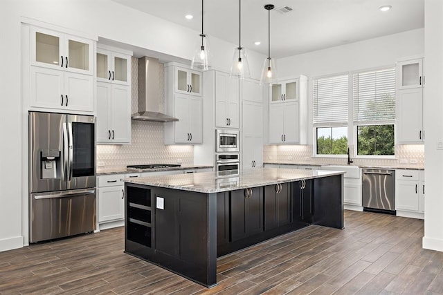 120 NW Strada Luca NW, Florence, TX 76527 - kitchen featuring stainless steel appliances, wall chimney range hood, white cabinets, a kitchen island, and backsplash