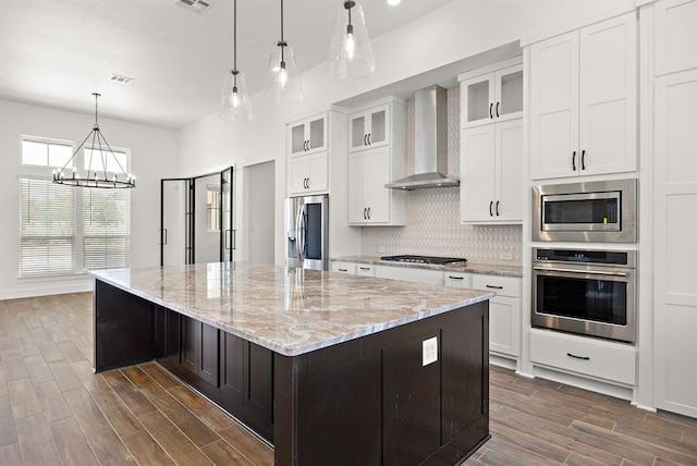 120 NW Strada Luca NW, Florence, TX 76527 - kitchen with appliances with stainless steel finishes, wall chimney range hood, a chandelier, a large island, and dark wood-style floors