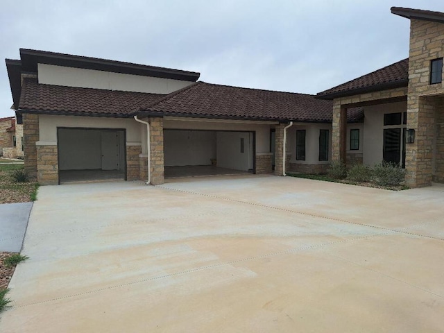 120 NW Strada Luca NW, Florence, TX 76527 - view of front of property featuring stone siding, concrete driveway, an attached garage, and stucco siding