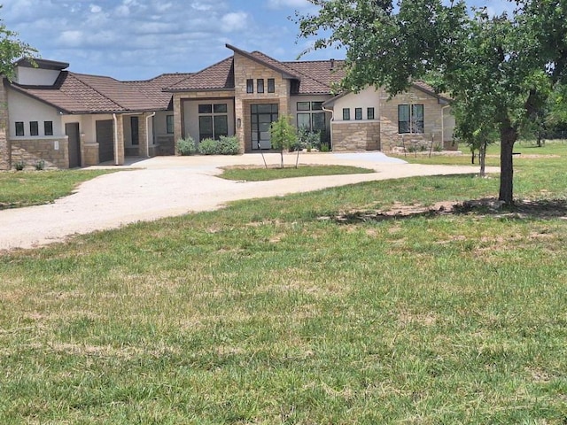 120 NW Strada Luca NW, Florence, TX 76527 - view of front of house with stone siding, a front lawn, stucco siding, and a tile roof