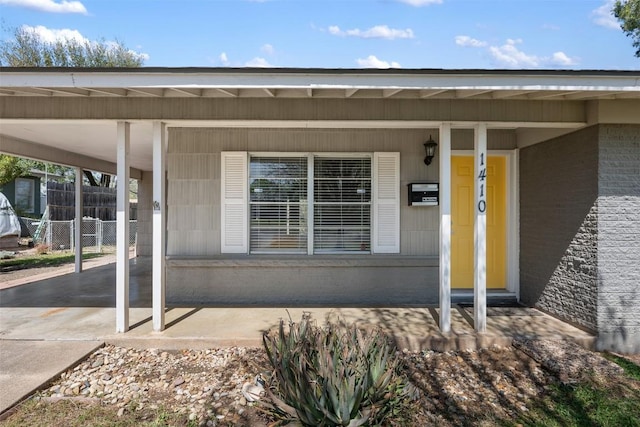 1410 Yorkshire Dr, Austin, TX 78723 - doorway to property with an attached carport, brick siding, and covered porch