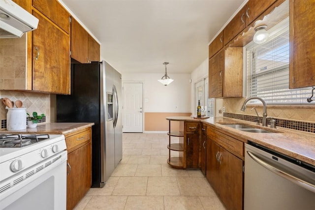 1410 Yorkshire Dr, Austin, TX 78723 - kitchen with stainless steel appliances, ventilation hood, backsplash, and brown cabinetry