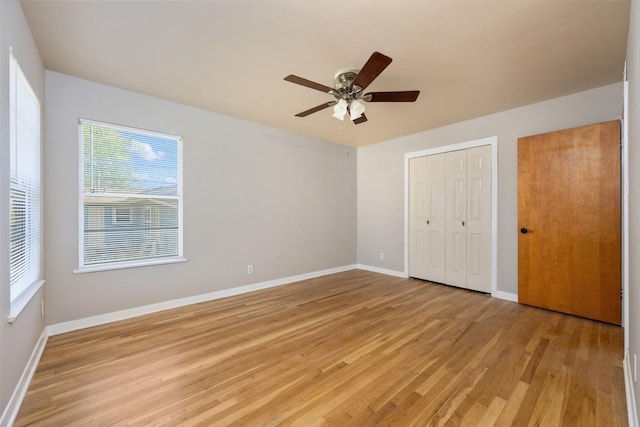 1410 Yorkshire Dr, Austin, TX 78723 - unfurnished bedroom with light wood-style flooring, multiple windows, a ceiling fan, and a closet